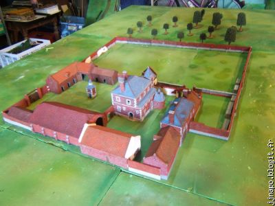 Remarquez le mur et la porte entre le château et la grande grange