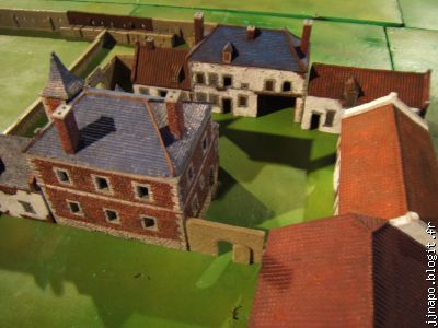 Zoom sur le château, qui a été incendié, et la maison du jardinier